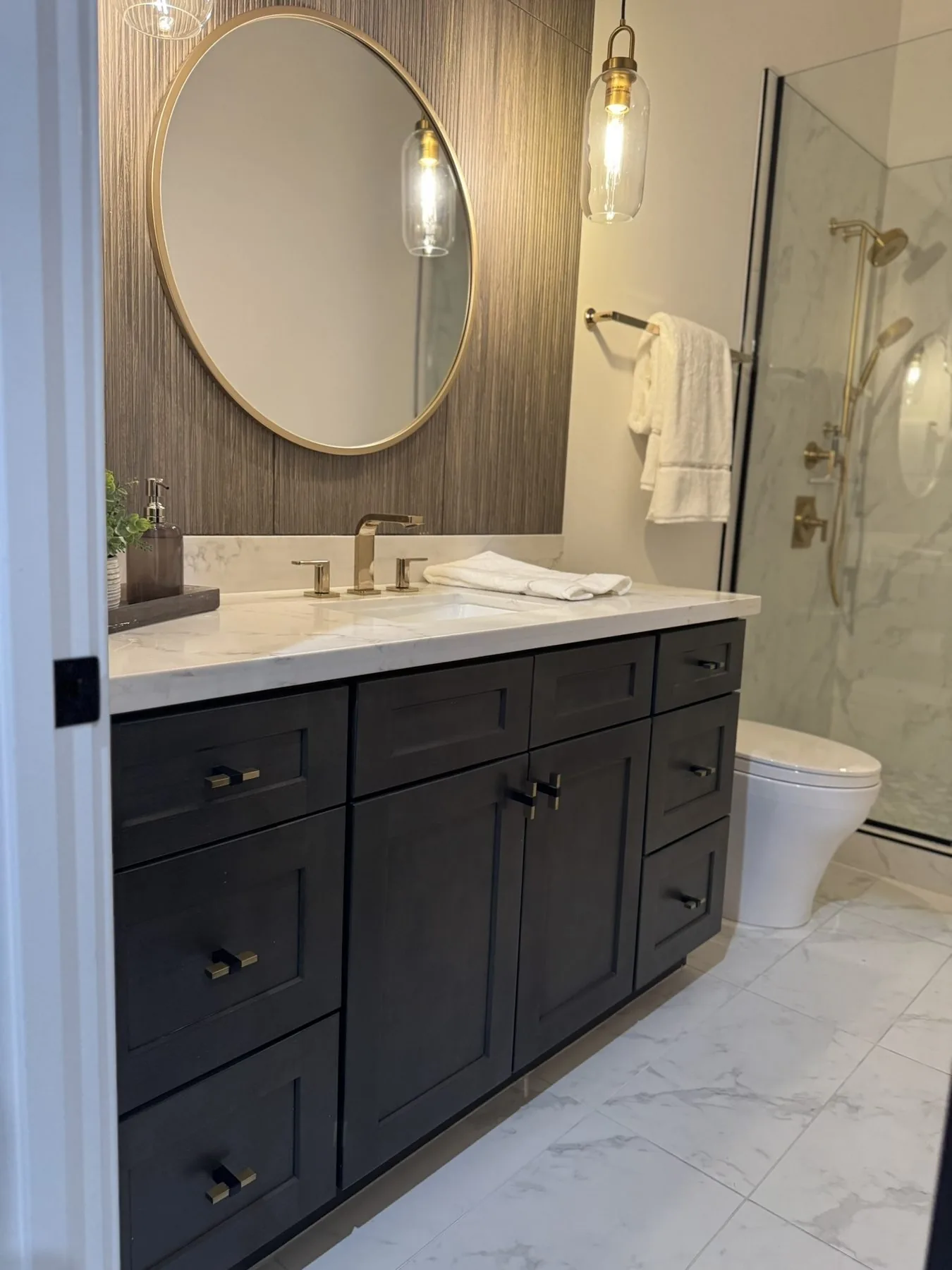 Bathroom vanity with round mirror and custom cabinetry