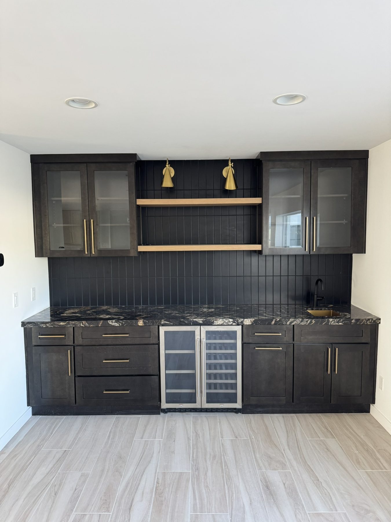 Dark stained kitchen cabinetry with brass hardware