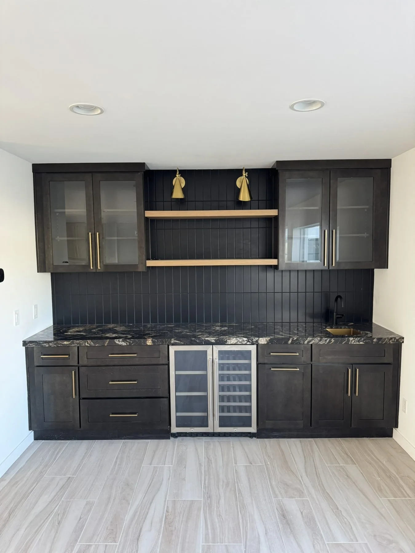 Dark stained kitchen cabinetry with brass hardware